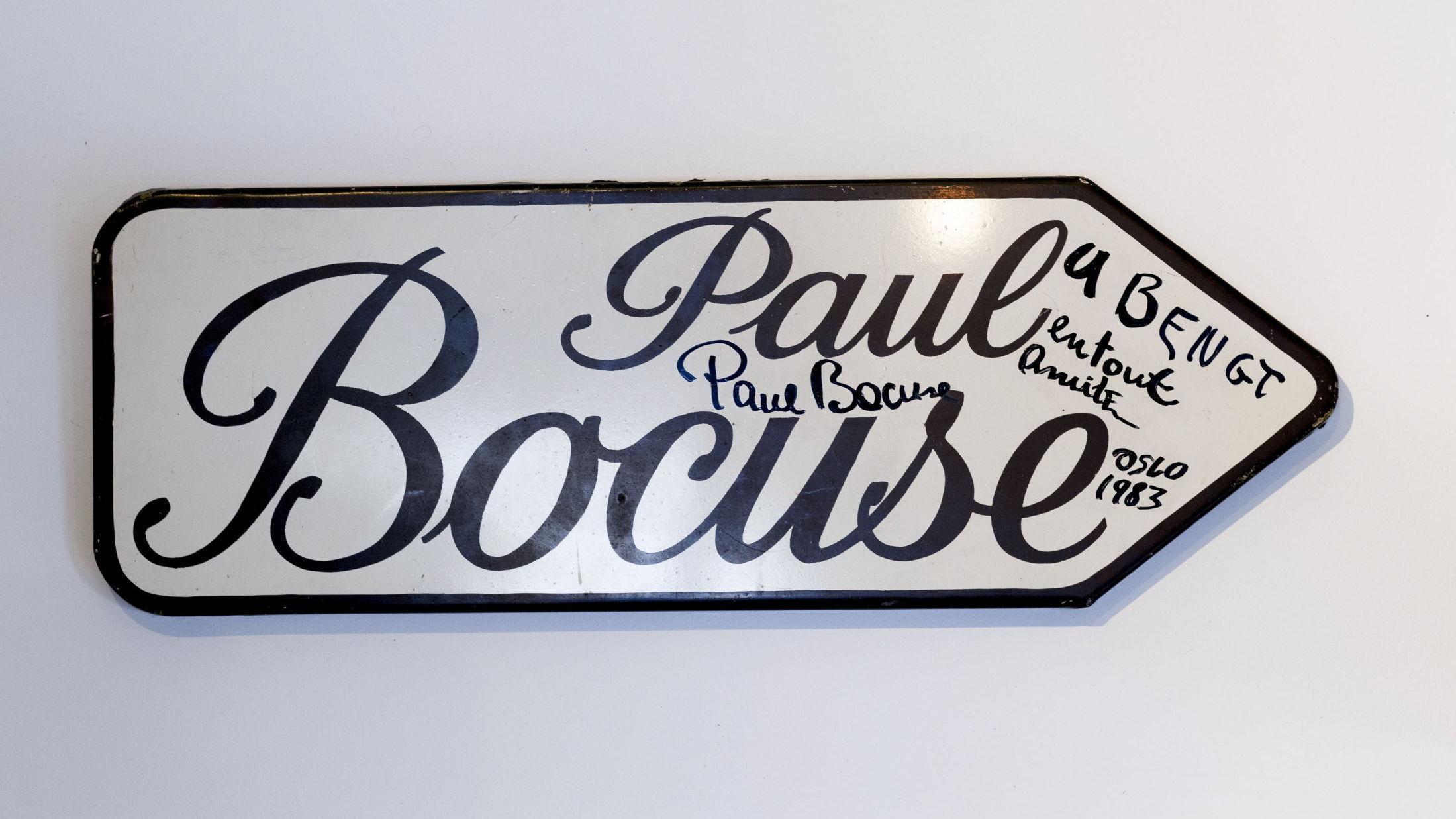 HILSEN: Skiltet som en gang hang utenfor Paul Bocuse' restaurant i Lyon henger nå med en personlig hilsen på Bent Stiansens vegg. Foto: Krister Sørbø/VG