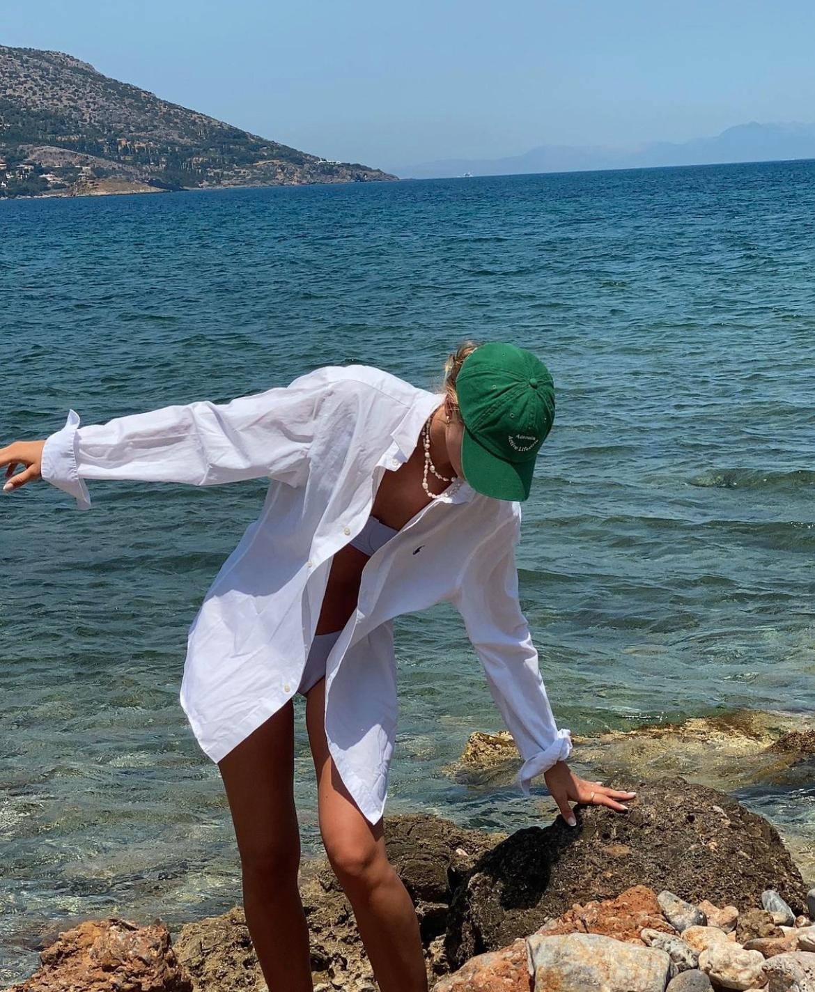 LEKRE SOMMERANTREKK: Den store bomullsskjorten passer ypperlig som strandplagg. Her er influencer Martine Akersveen på ferie i sin skjorte. 