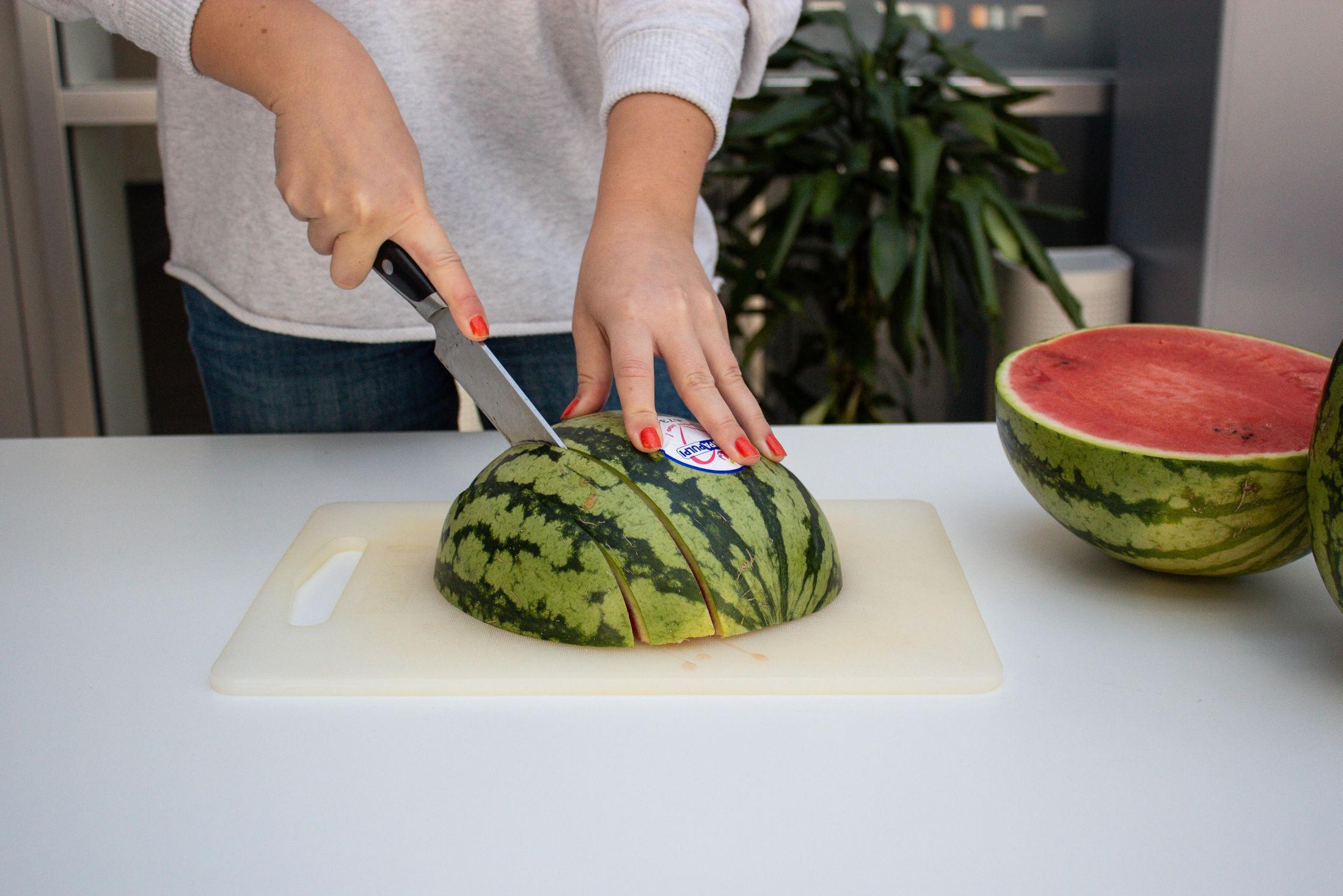 Steg 1: Kjøp en halv vannmelon, eller del en hel i to. Legg den ene halvdelen med den flate siden ned mot skjærebrettet. Deretter skjærer du melonen i skiver på langs.