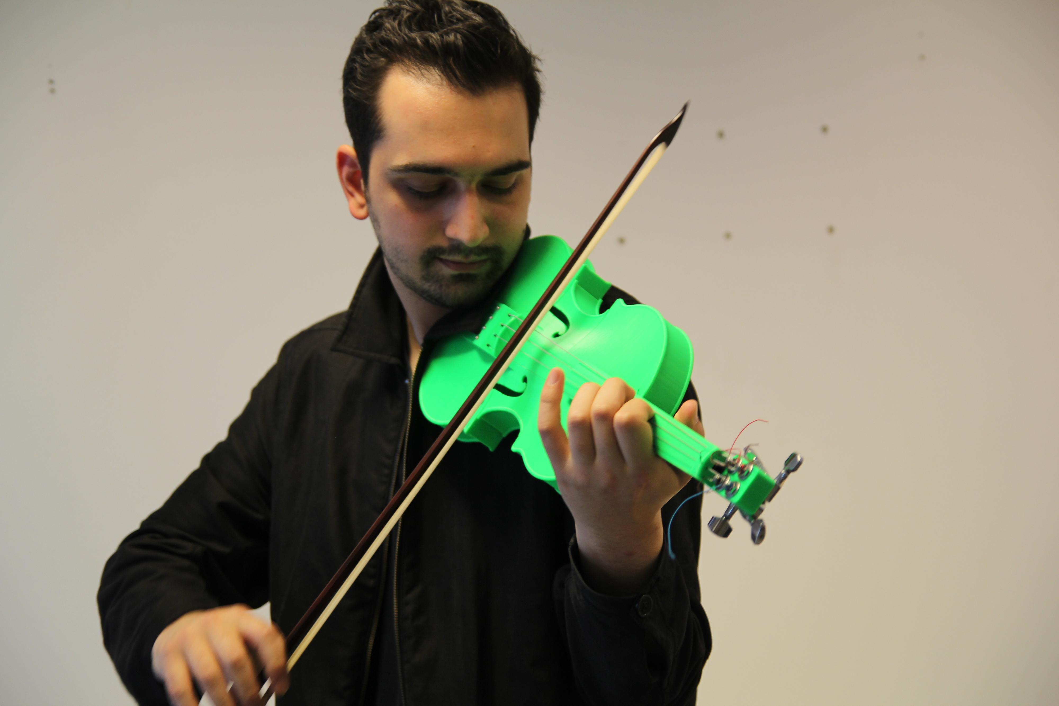 Koka Nicoldze er profesjonell musiker, og 3D-skriver-entusiast. Her tester han fiolinen Kim Øyhus har konstruert.
