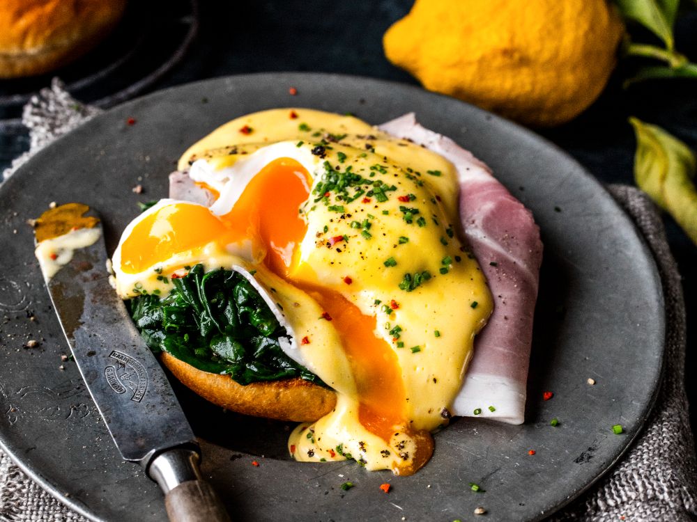 Ägg benedict är en klassisk rätt med pocherade ägg, hollandaisesås och spenat.