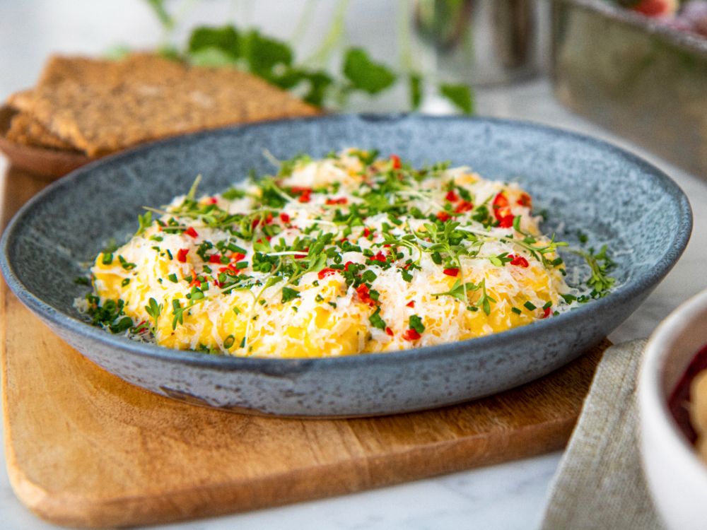 Toppa äggröran med riven parmesan, gräslök och chili.