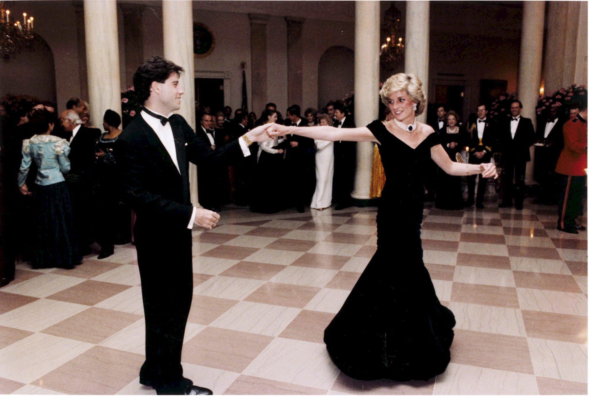 1985: Prinsesse Diana og skuespiller John Travolta fikk de andre gjestene i Det hvite hus til å måpe da de svinget seg på dansegulvet. Fløyelskjolen uten skuldre, designet av Victor Edelstein, regnes i dag som et av de mest kjente antrekkene hennes.