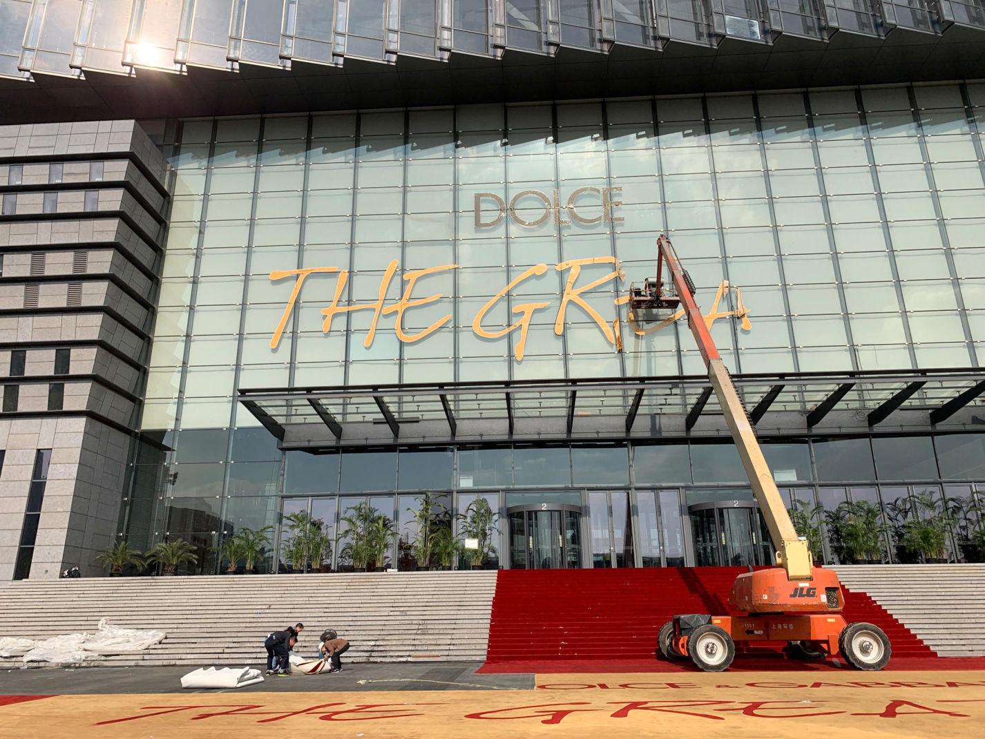 BLE IKKE NOE AV: Arbeidere måtte fjerne skiltene som på arenaen som skulle huse «Dolce & Gabbana The Great Show» i Shanghai. Foto: Reuters.