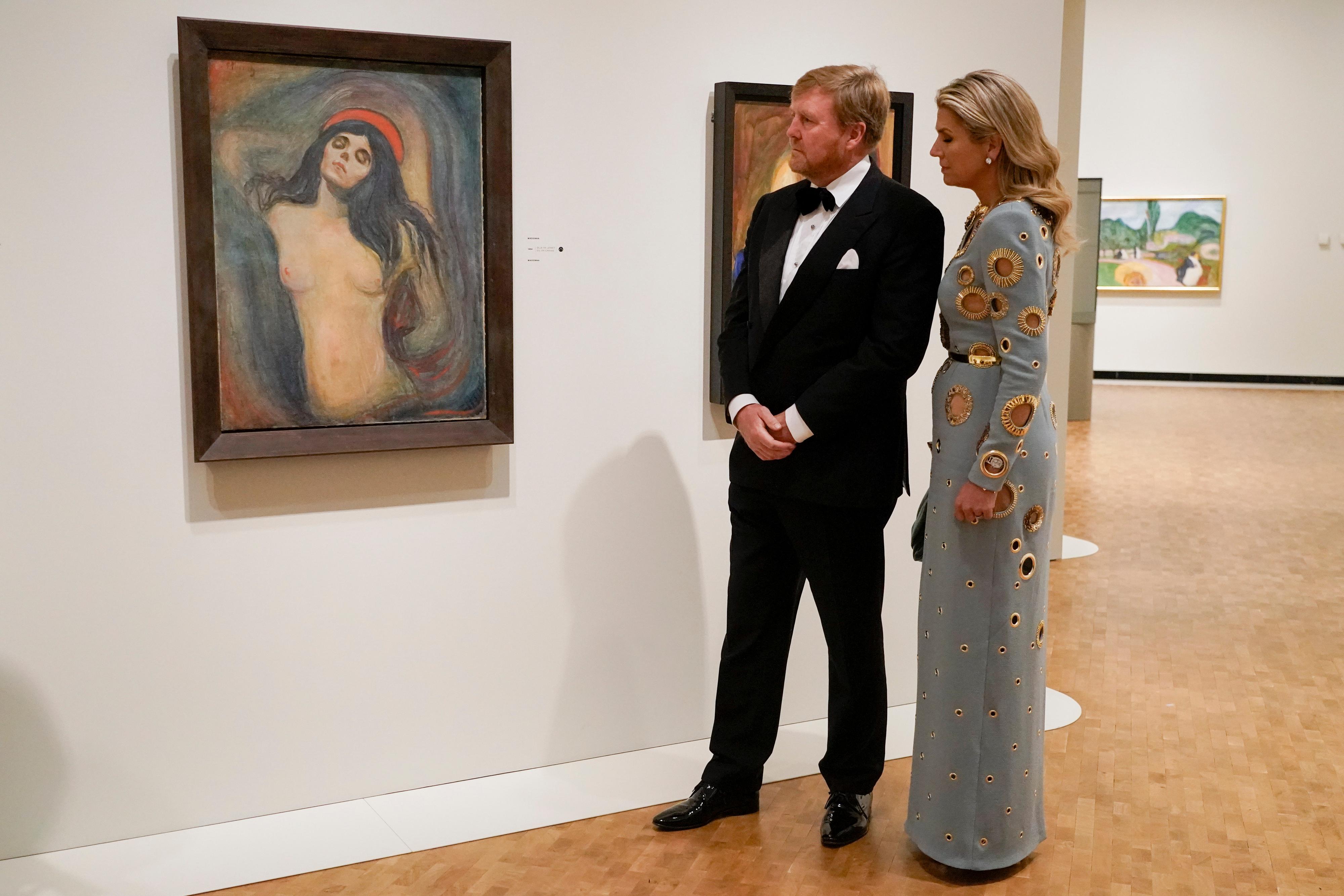 KUNSTVERK: Kong Willem-Alexander og dronning Maxima ser på kunstverket Madonna mens dronningen selv har på seg litt av et kunstverk av en kjole.