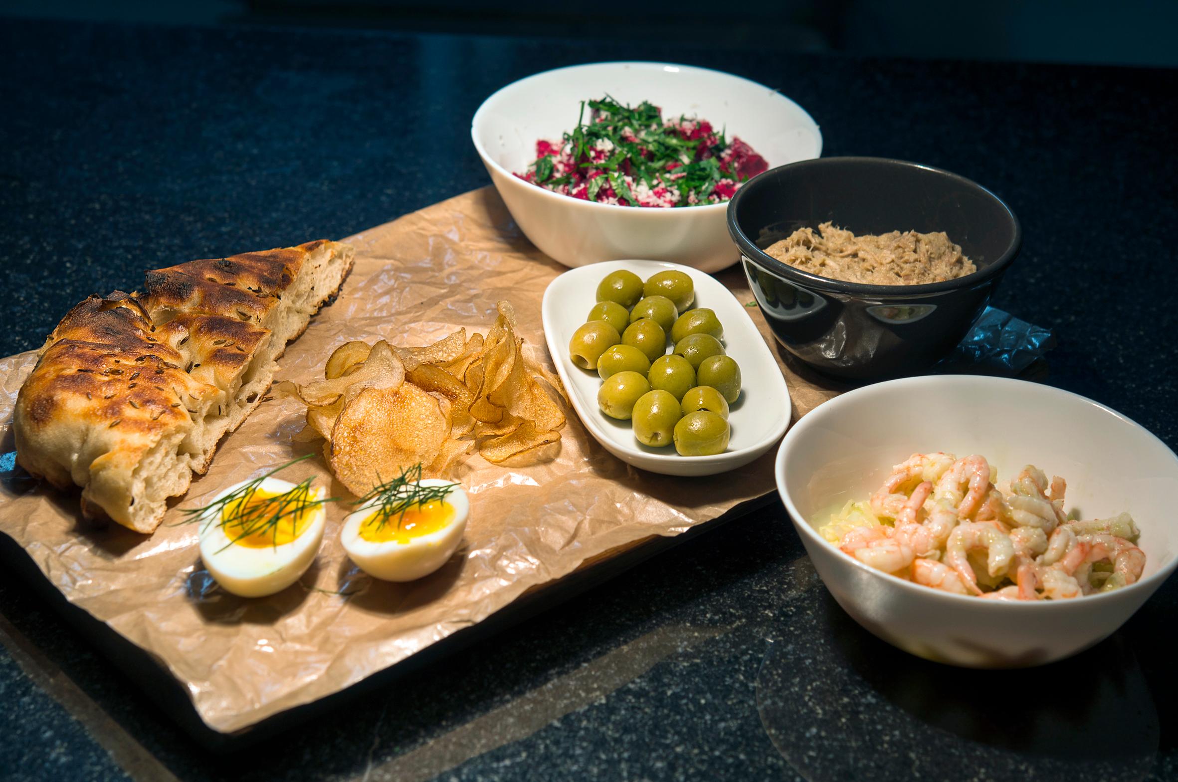 Snack på fjøl; Grilletbrød, rødbettartar, rillettes av svineribbe kokt i andefett, sylta egg, potetchips, oliven og reker med coleslaw