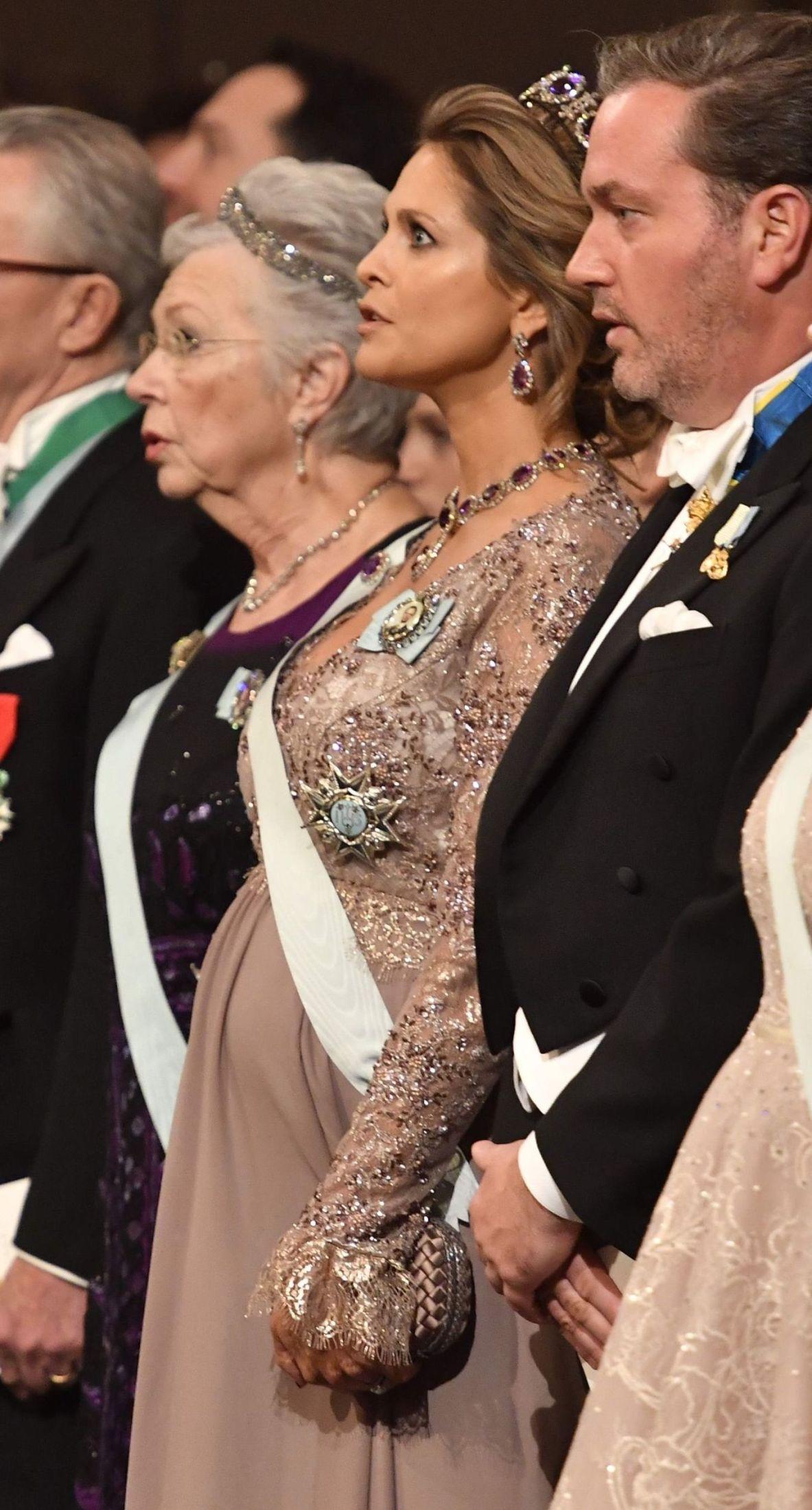 FREMHEVET MAGEN: Prinsesse Madeleine hadde en pudderfarget, rosa kjole med blondeoverdel. Kjolen med høyt liv fremhevet babymagen. Foto: AFP