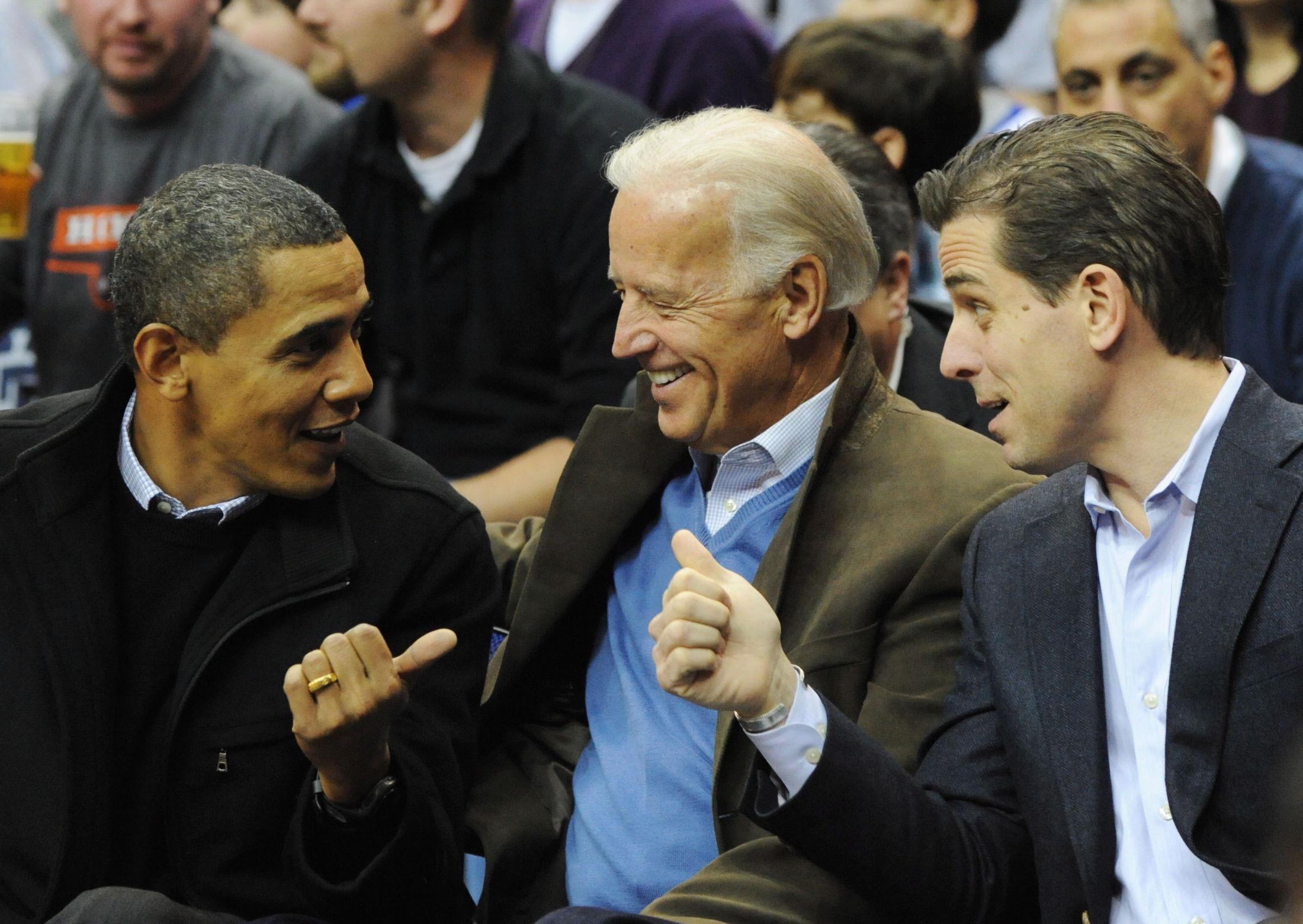 HVERDAGSCLASSY: Joe Biden med daværende president Barack Obama, og sønnen Hunter, under en basketballkamp i 2010. Biden gikk for en olivengrønn blazer, som spiller godt på lag med den lyseblå ullgenseren under. Genseren plukker også opp fargen fra stripene på skjorten. Foto: Alexis C. Glenn, EPA / NTB
