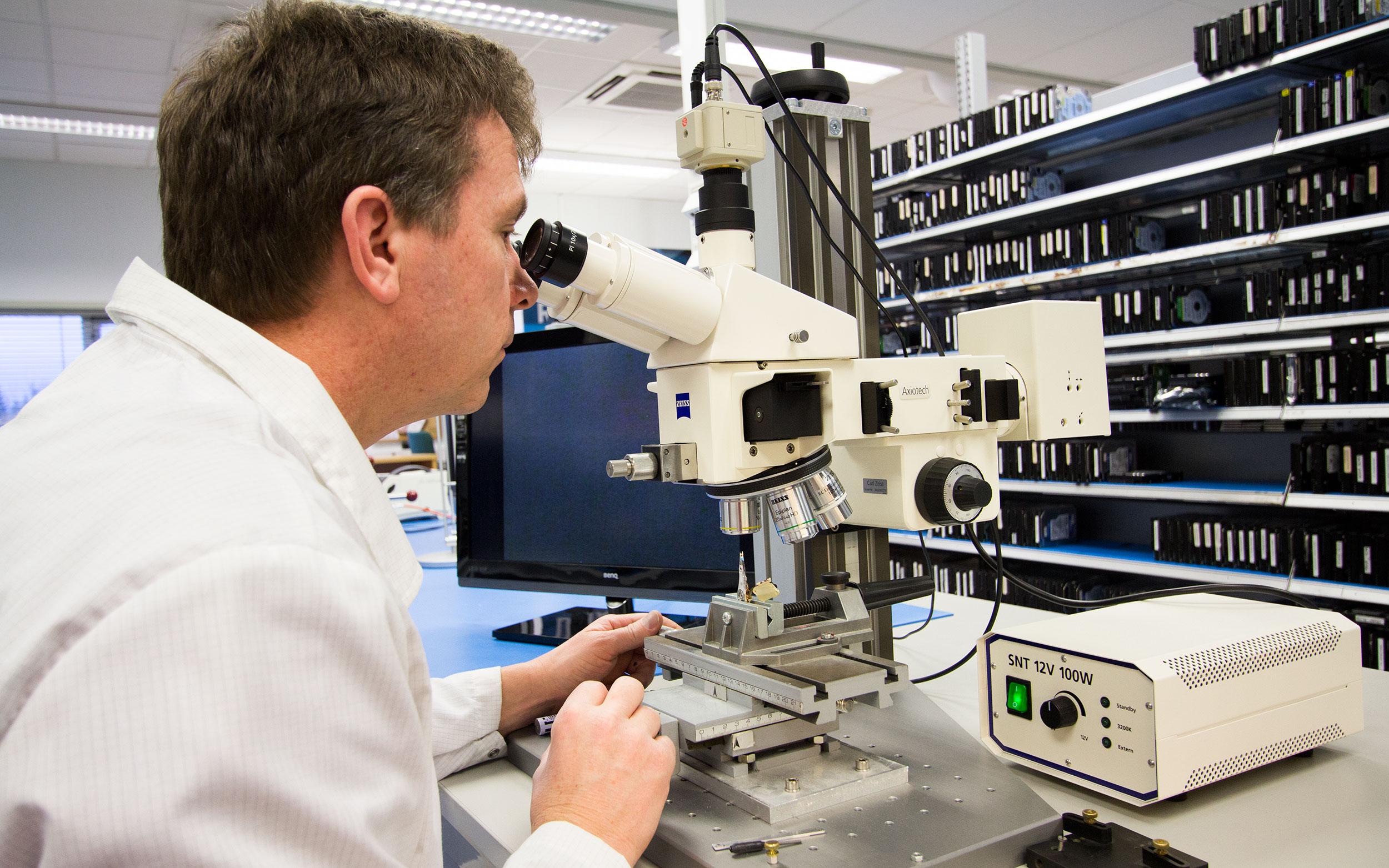 Hans Rønningen, sjef for renrommet til IBAS, studerer lese- og skrivehodet til en harddisk under mikroskop.Foto: Vegar Jansen, Hardware.no