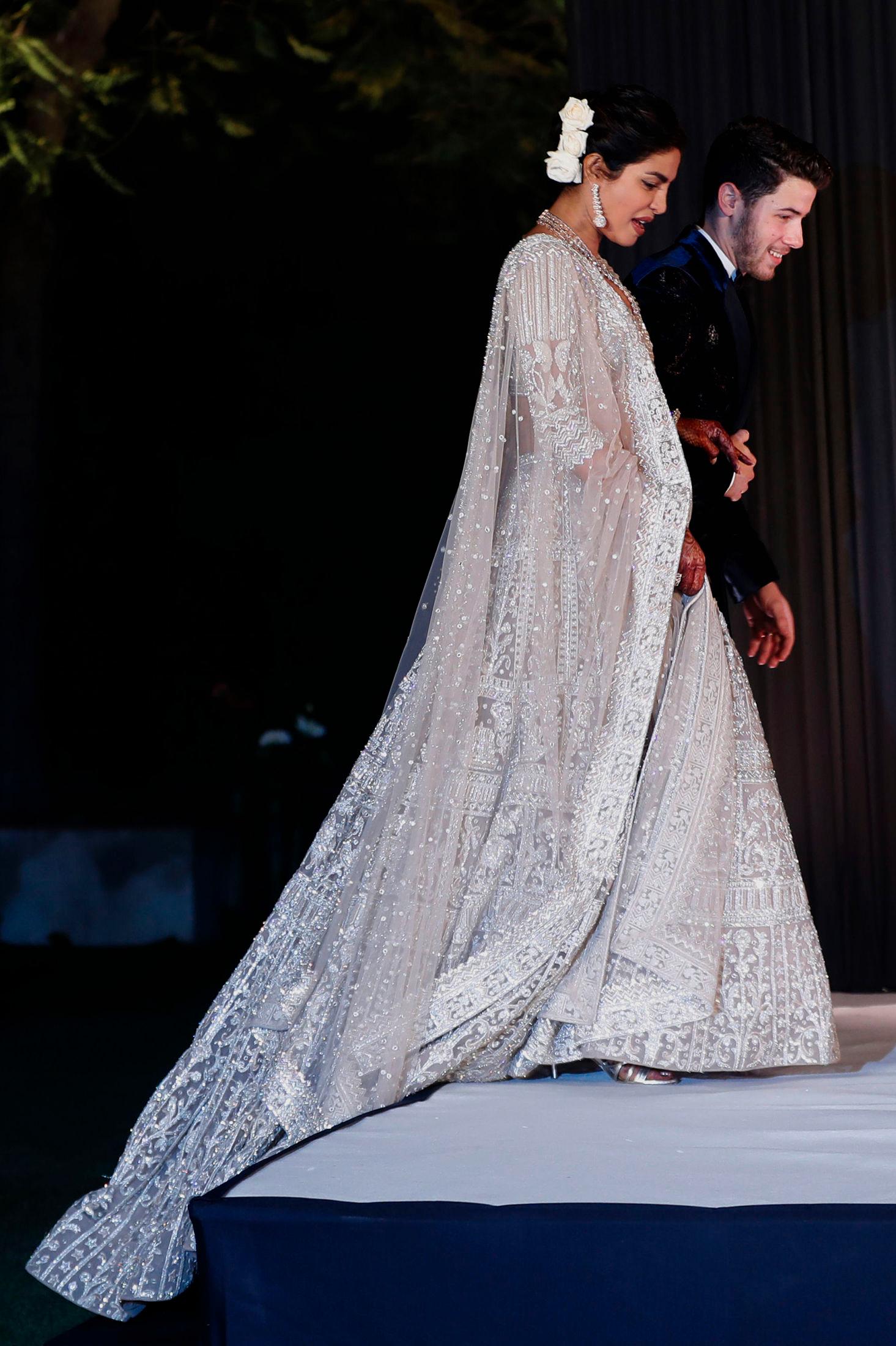 VAKKER: Priyanka Chopra hadde på seg en nydelig kjole fra merket Falguni Peacock, under en av parets mange bryllupsmottagelser. Kjolen skal ha tatt 12.000 timer å lage. Her i New Delhi i India, 4. desember 2018. Foto: AP.
